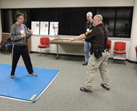 officer instructs attendee in self-defense